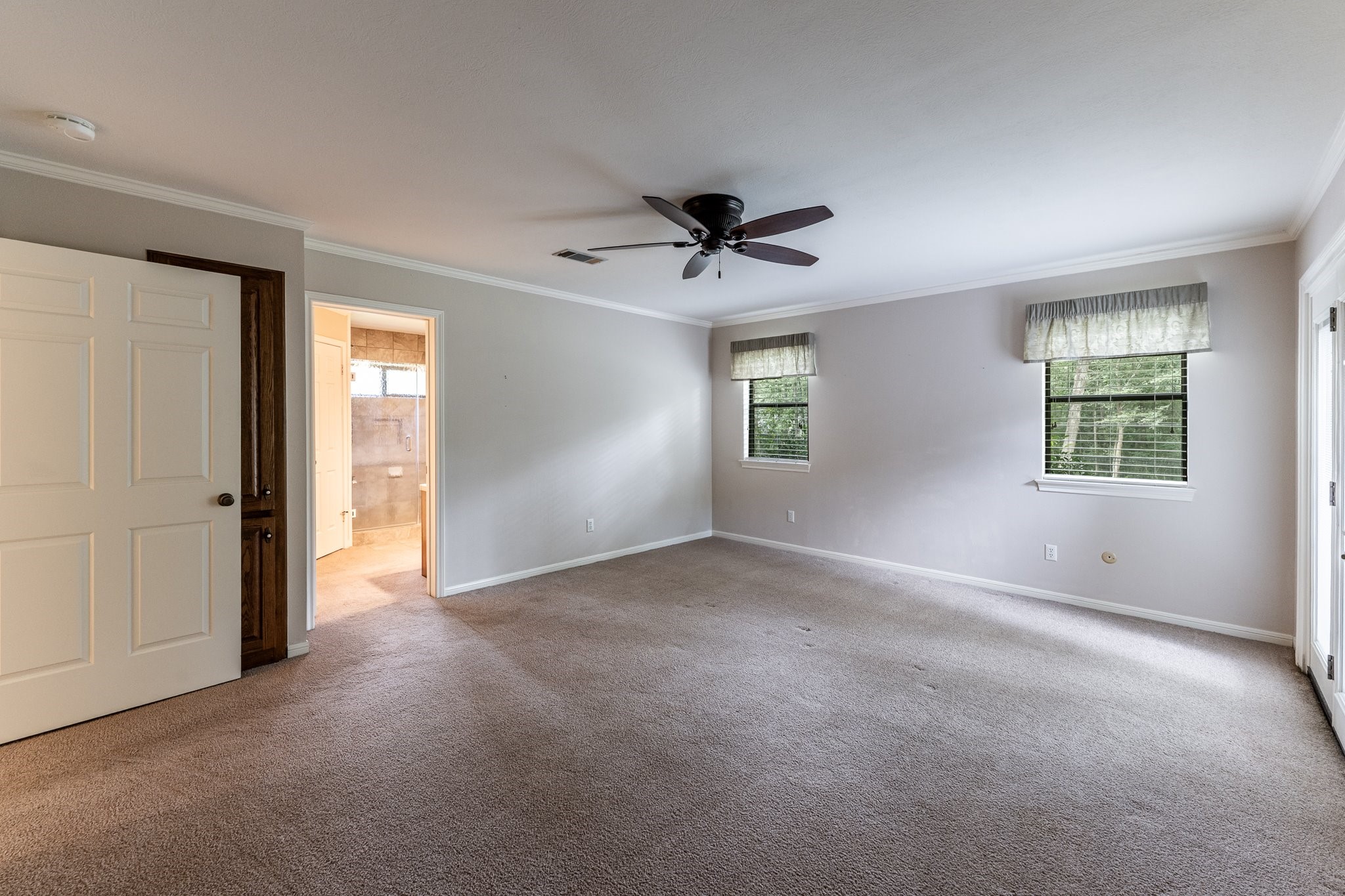104 Oakview Circle Huntsville, TX 77340 - Photo 16 of 36 an empty room with windows and chandelier fan