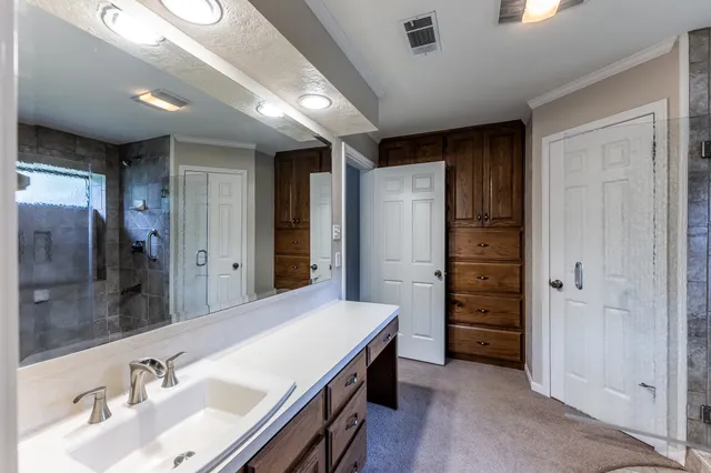 a en suite bathroom with a granite countertop sink and a mirror