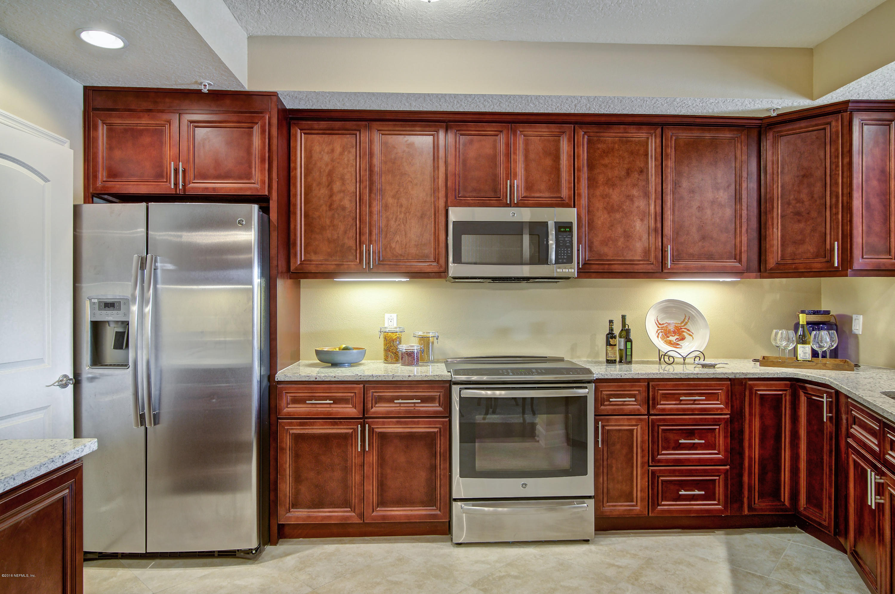 3958 Baymeadows Road, Unit 4402 Jacksonville, FL 32217 - Photo 9 of 14 a kitchen with stainless steel appliances granite countertop a refrigerator and a stove top oven