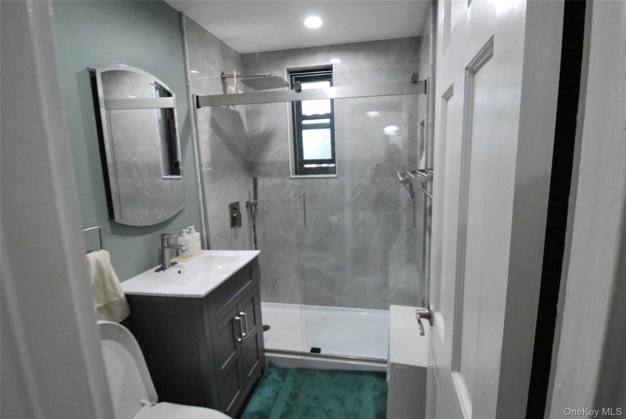 106 Richbell Road, Unit B2 Mamaroneck, NY 10543 - Photo 8 of 16 a bathroom with a double vanity sink mirror and shower