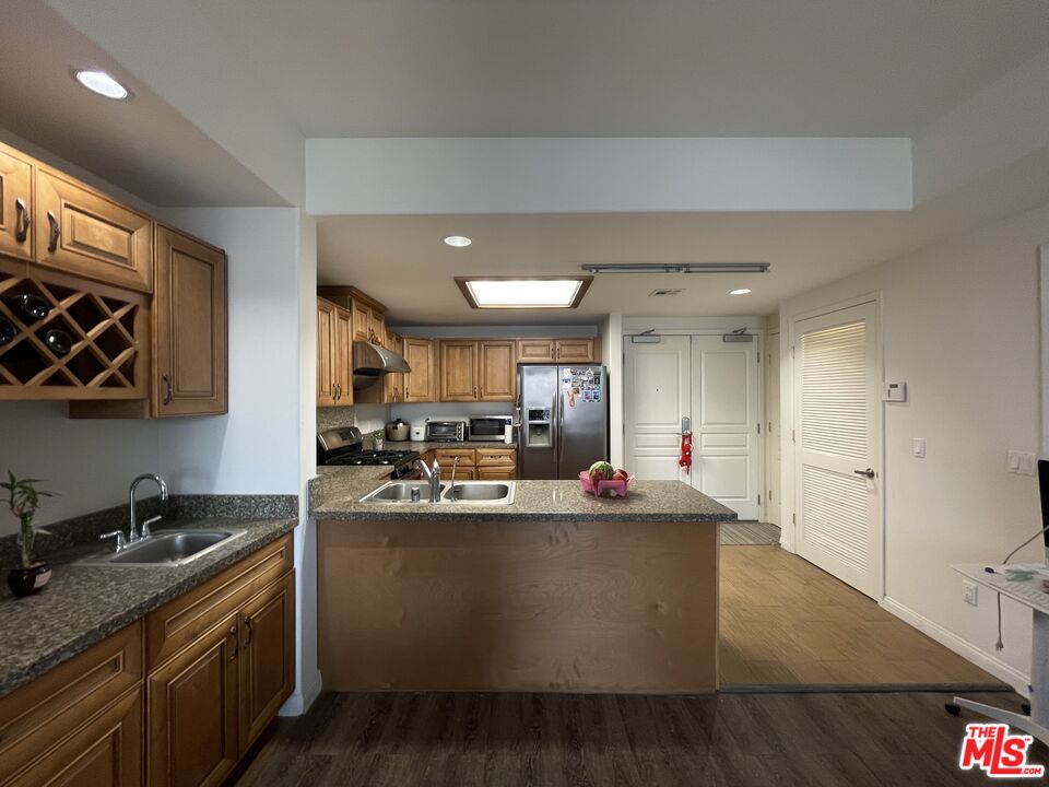 11 South 3rd Street, Unit 502 Alhambra, CA 91801 - Photo 29 of 33 a kitchen with kitchen island a sink stove top oven and cabinets