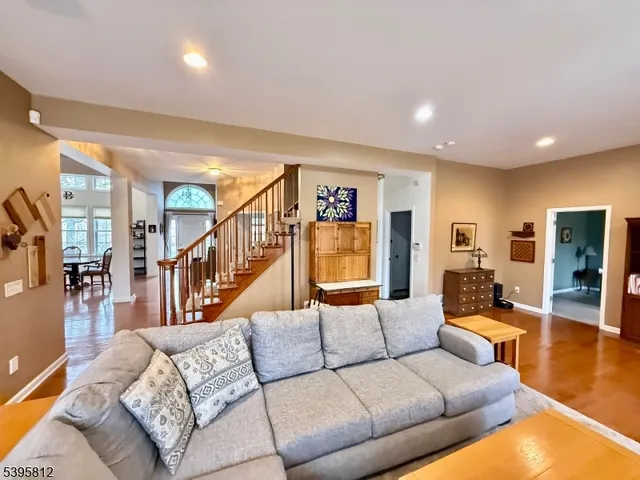 a living room with furniture kitchen view and a wooden floor