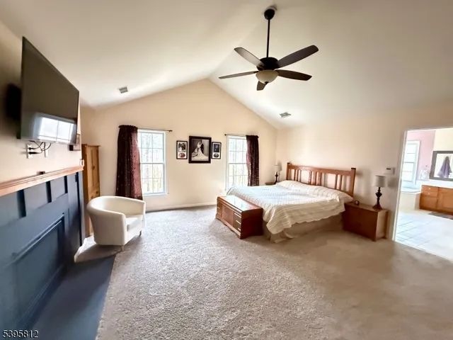 a spacious bedroom with a bed a couch and a flat screen tv