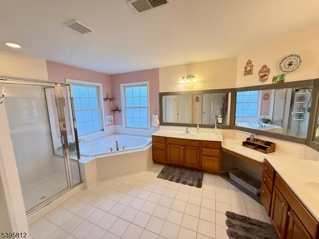a spacious bathroom with a tub sink shower and mirror