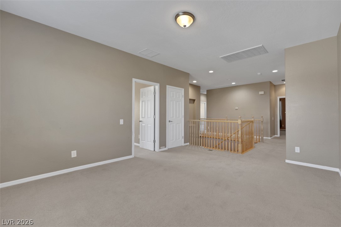 2501 Bechamel Place Henderson, NV 89044 - Photo 21 of 50 A spacious second-story landing offers generous living space with soft carpeting and natural wood banisters.