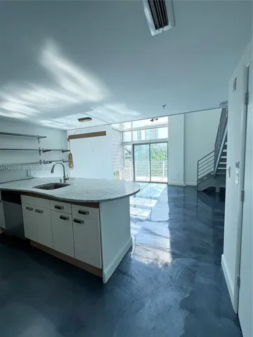 a kitchen with granite countertop a sink and a stove