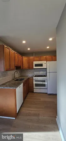 a view of kitchen with stainless steel appliances granite countertop a stove and a sink