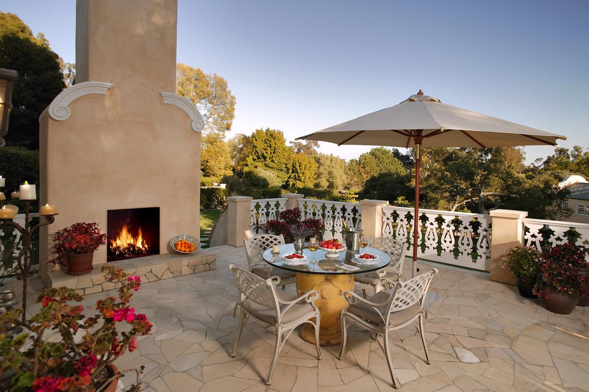 1401 School House Road Montecito, CA 93108 - Photo 7 of 9 a table and chairs in front of yellow house