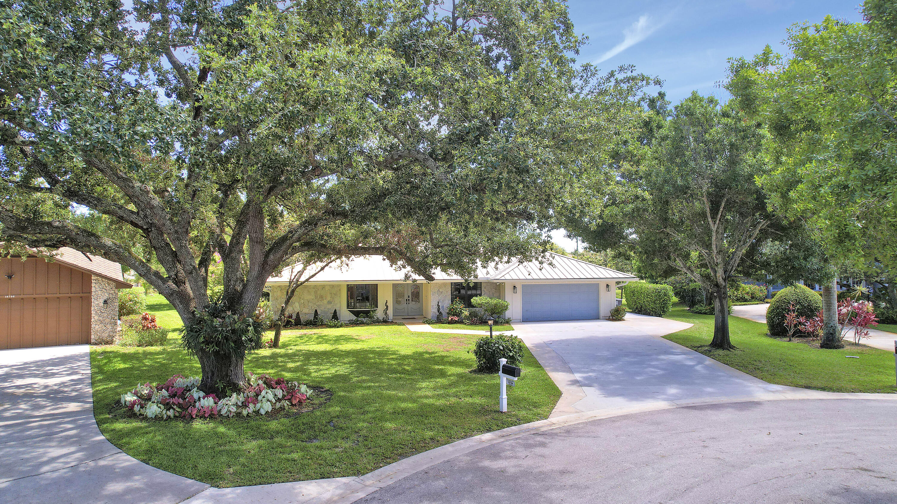 18784 Falcon Way Jupiter, FL 33458 - Photo 2 of 47 a front view of a house with garden