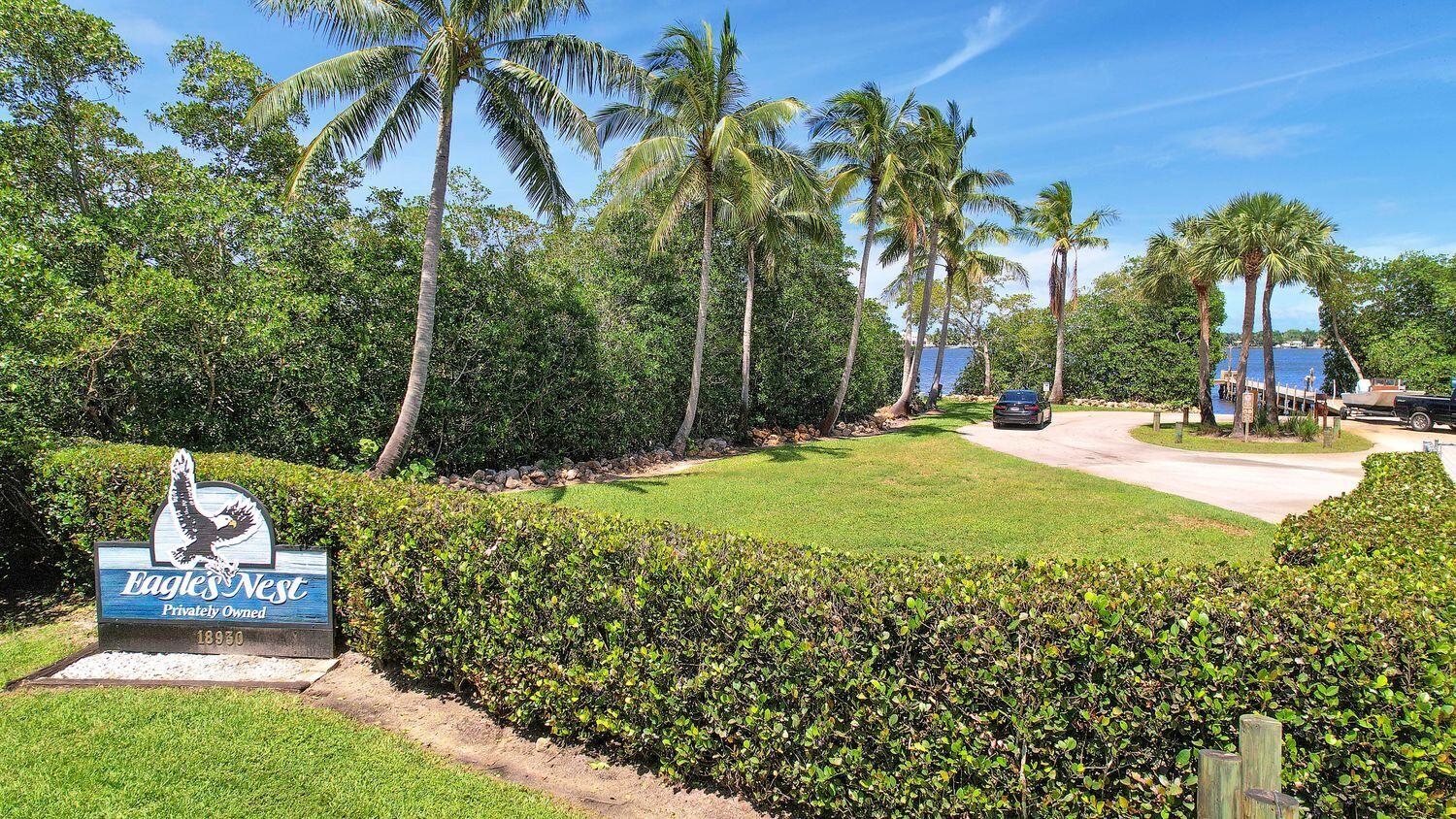 18784 Falcon Way Jupiter, FL 33458 - Photo 39 of 47 a backyard of a house with table and chairs plants and large trees