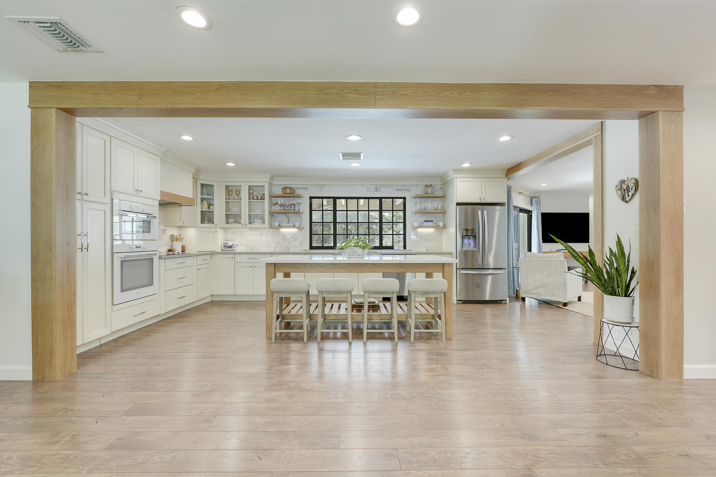18784 Falcon Way Jupiter, FL 33458 - Photo 8 of 47 a dining hall with stainless steel appliances a dining table chairs and couches with wooden floor