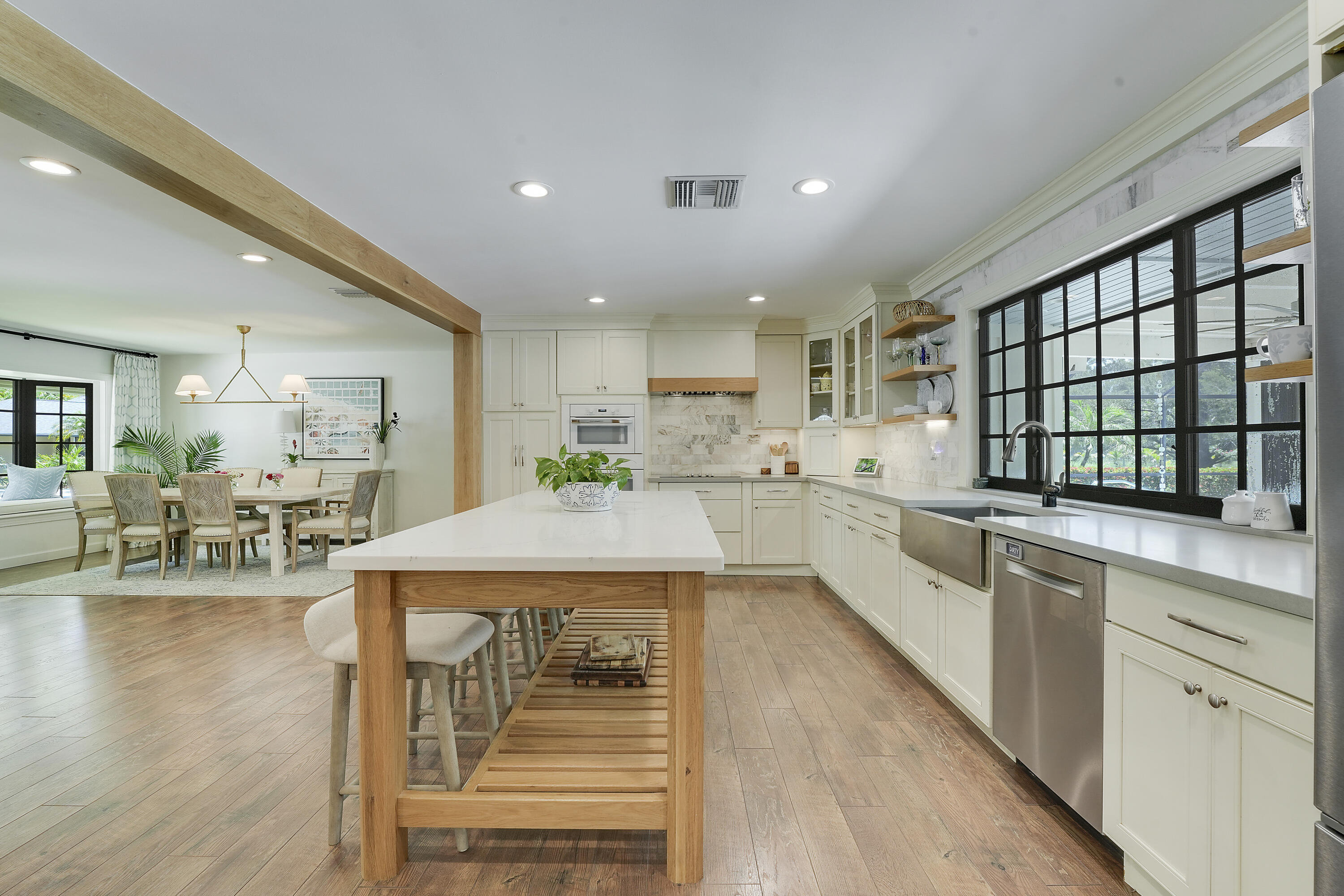 18784 Falcon Way Jupiter, FL 33458 - Photo 10 of 47 a kitchen with stainless steel appliances granite countertop a stove top oven a sink a dining table and chairs with wooden floor