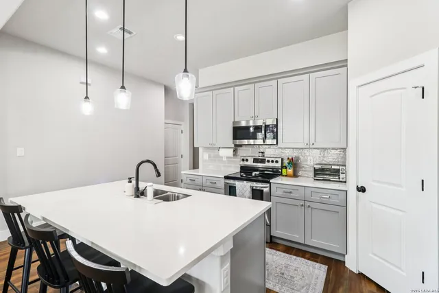 a kitchen with stainless steel appliances a white table and chairs