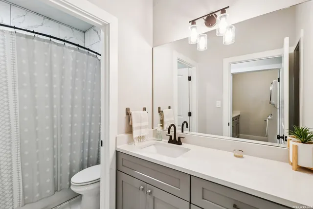 a bathroom with a sink a toilet and shower curtain