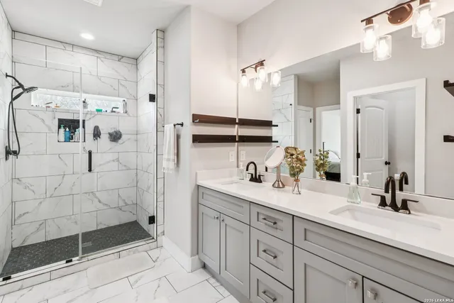 a bathroom with a double sink shower and a mirror