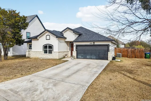 a view of house with a yard and garage