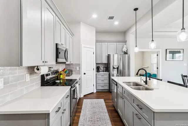 a kitchen with stainless steel appliances a sink stove and refrigerator