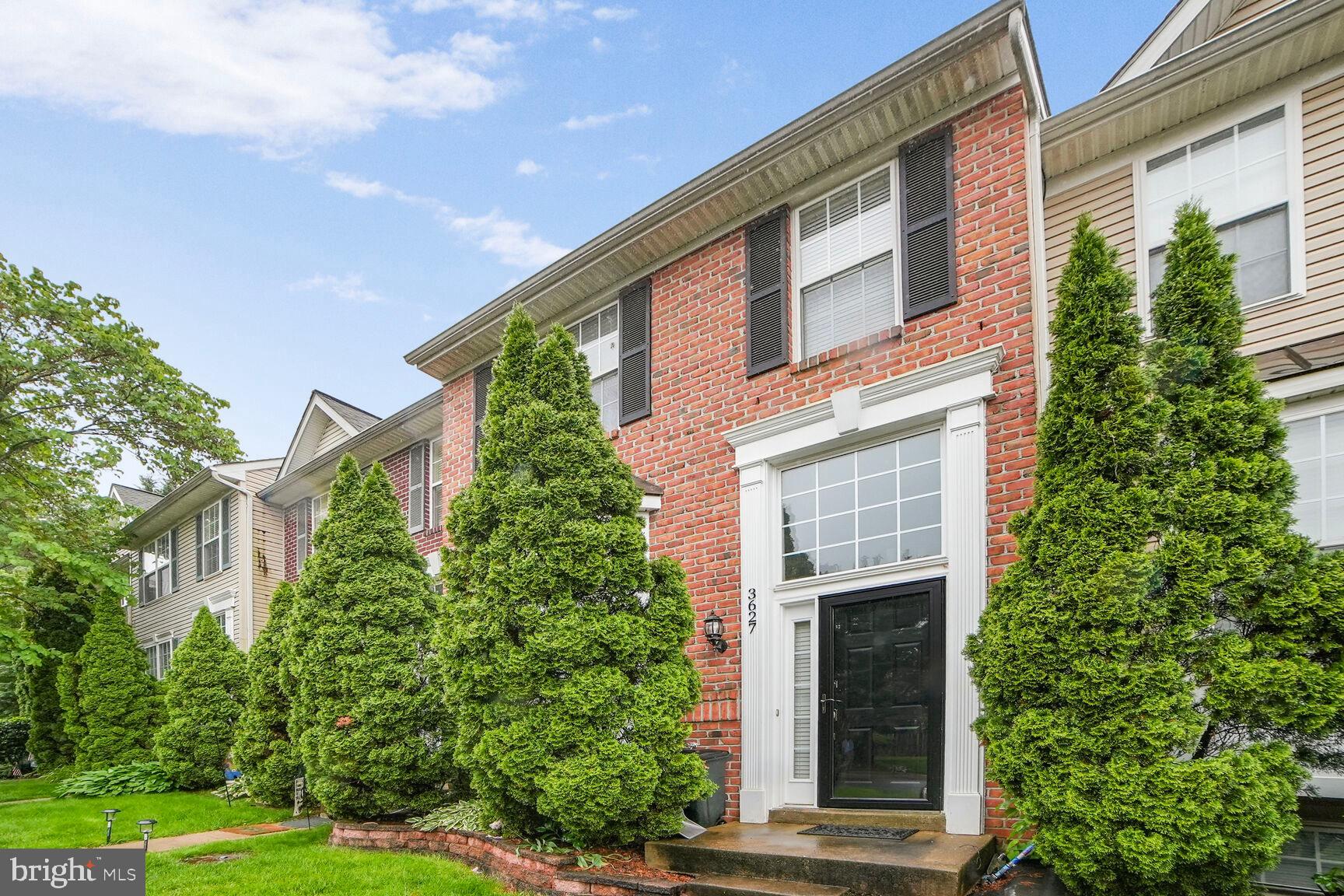 a front view of a house with plants and garden