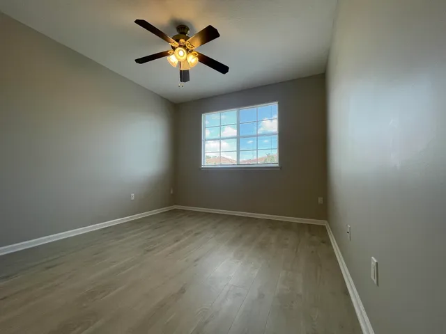an empty room with a window and a fan