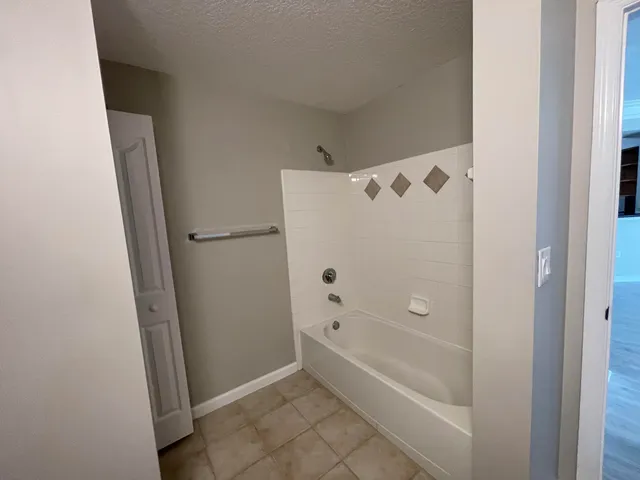 a bathroom with bathtub shower and toilet