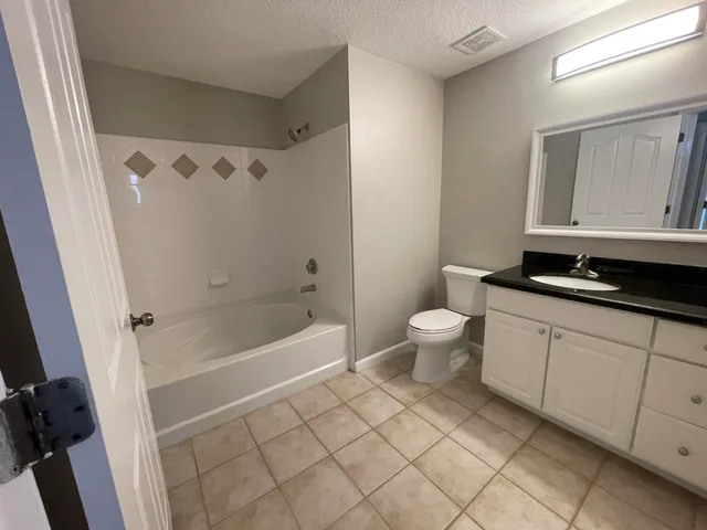 a bathroom with a bathtub sink mirror and toilet