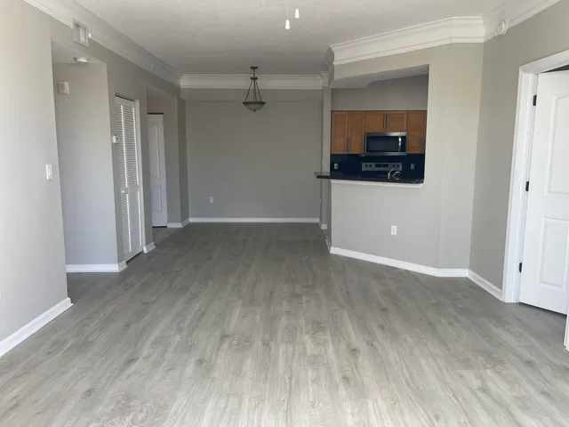 a view of a room with wooden floor and electronic appliances