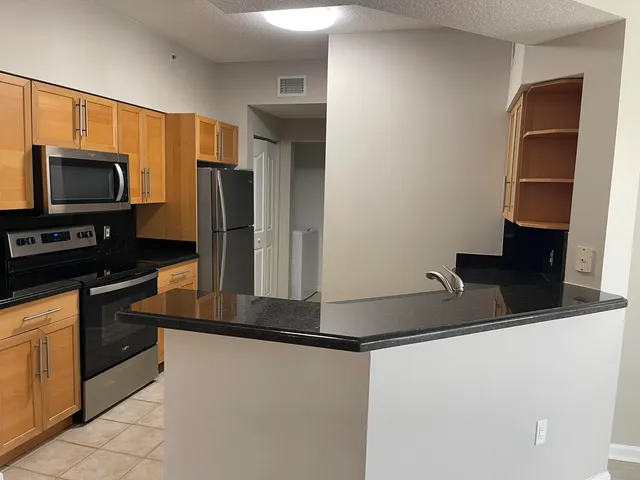 a kitchen with kitchen island a refrigerator and a sink