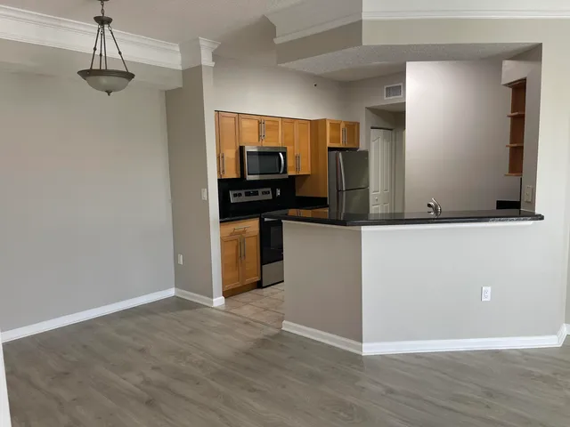 a kitchen with stainless steel appliances granite countertop a refrigerator and a stove top oven