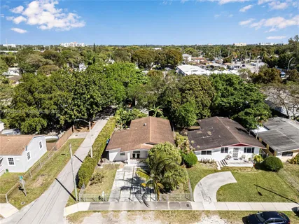 an aerial view of residential houses with outdoor space and trees