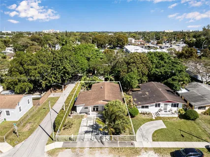 an aerial view of residential houses with outdoor space and trees