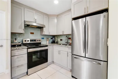 a kitchen with stainless steel appliances a refrigerator sink and cabinets