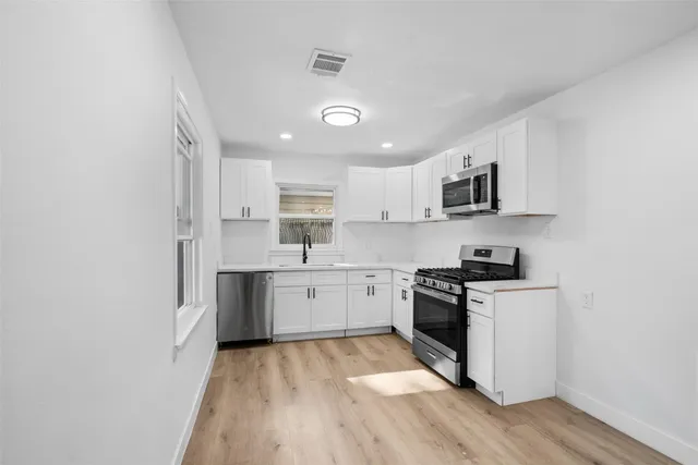 a view of a kitchen with wooden floor and electronic appliances