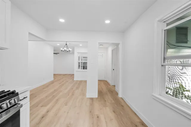 a view of an empty room and window a ceiling fan