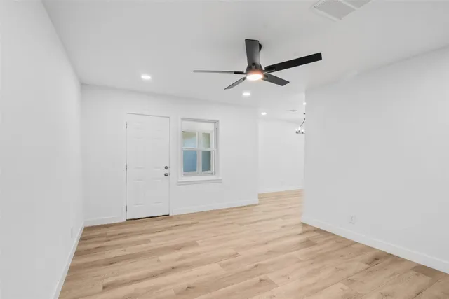 an empty room with a window and a ceiling fan