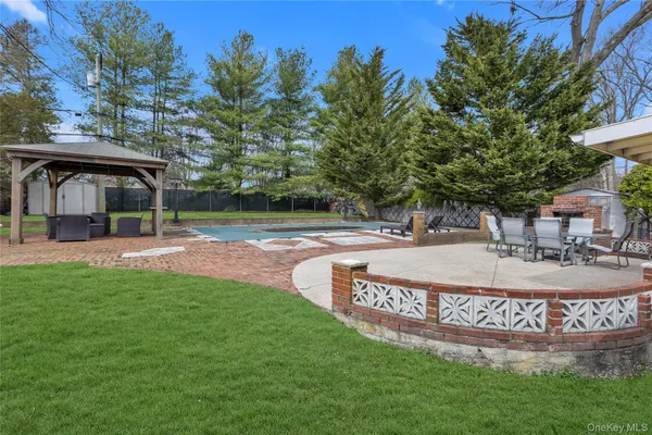 a view of a house with a patio and a yard