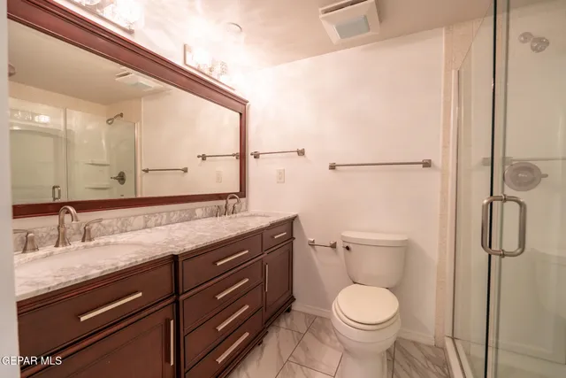 a bathroom with a granite countertop toilet sink and mirror