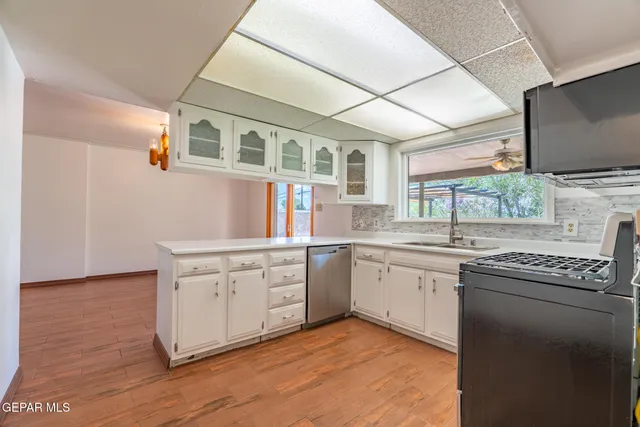 a kitchen with granite countertop cabinets stainless steel appliances a sink and a window