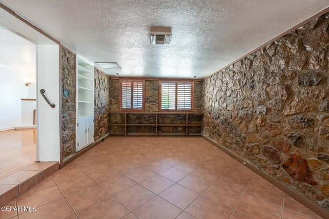 an empty room with a window and a ceiling fan