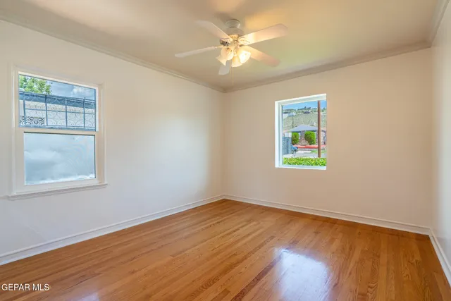 a view of an empty room with window and wooden floor