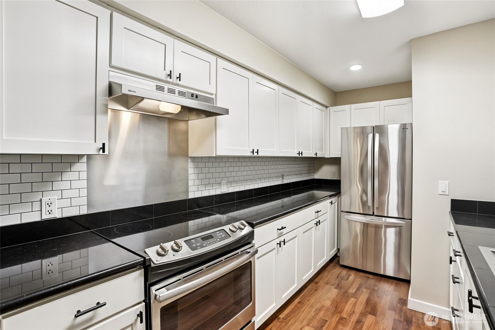 12303 Harbour Pointe Boulevard, Unit W101 Mukilteo, WA 98275 - Photo 10 of 25 a kitchen with granite countertop a refrigerator stove and wooden floor
