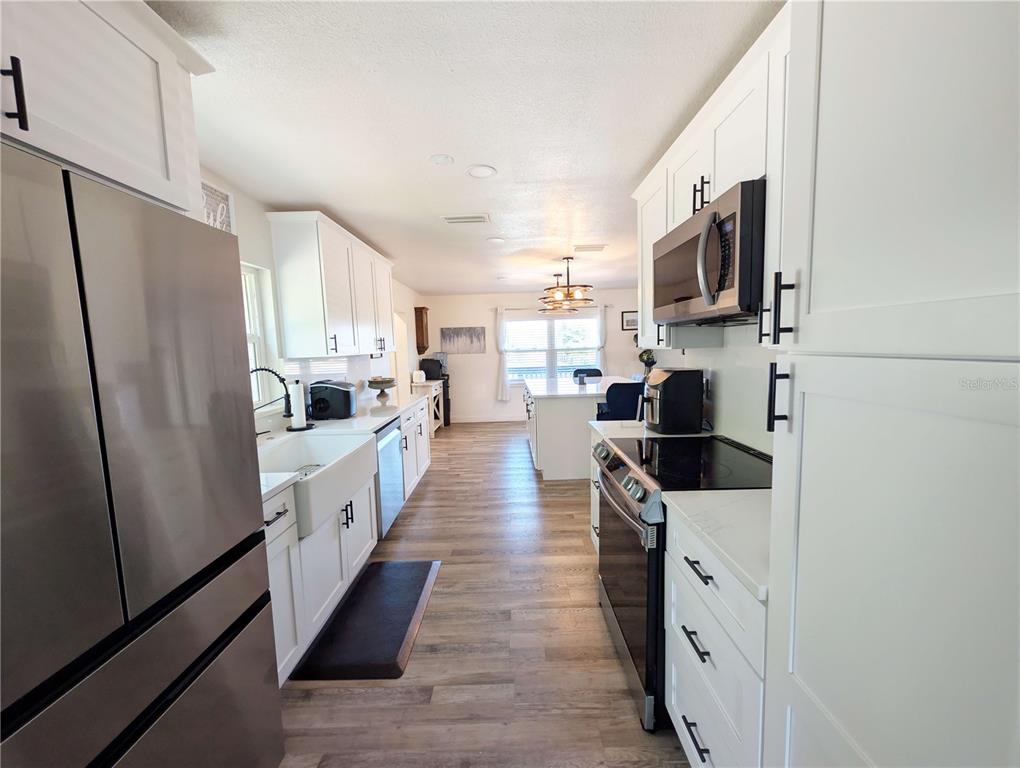 1007 77th Street East Palmetto, FL 34221 - Photo 9 of 39 a kitchen with stainless steel appliances a refrigerator sink and microwave