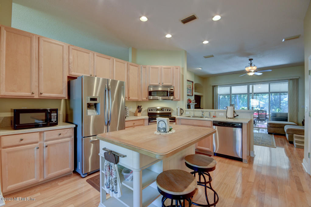 97071 Castle Ridge Drive Yulee, FL 32097 - Photo 11 of 26 a kitchen with a sink a kitchen island stainless steel appliances and cabinets