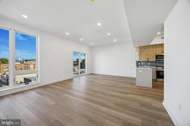 an empty room with wooden floor and entrance to ceiling window