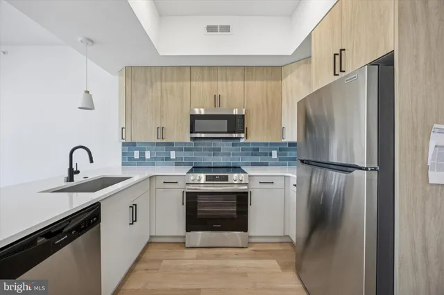 a kitchen with stainless steel appliances granite countertop a refrigerator sink and stove