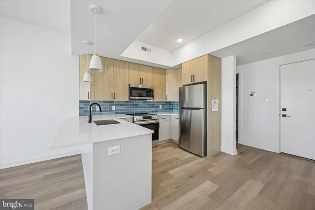 a kitchen with a refrigerator sink and cabinets