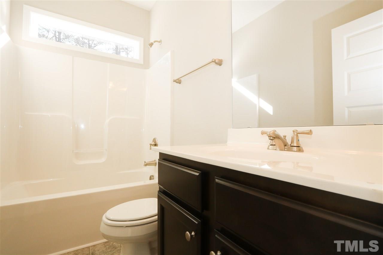 1035 2 Claude Road Willow Spring, NC 27592 - Photo 15 of 18 a bathroom with a sink a toilet a mirror and shower