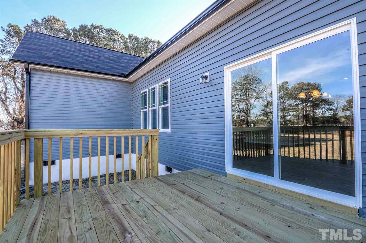1035 2 Claude Road Willow Spring, NC 27592 - Photo 16 of 18 a view of a brick house with wooden floor and fence
