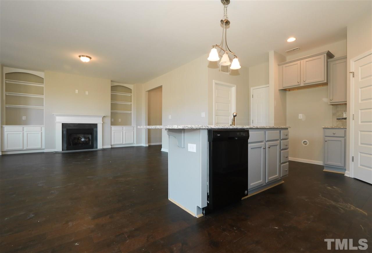 1035 2 Claude Road Willow Spring, NC 27592 - Photo 5 of 18 a kitchen with a sink chandelier and a fireplace