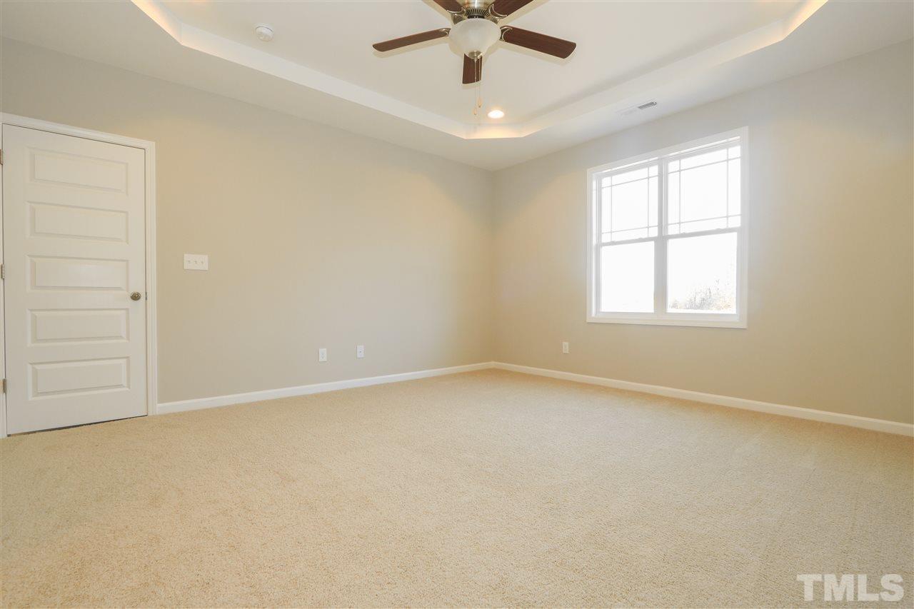 1035 2 Claude Road Willow Spring, NC 27592 - Photo 9 of 18 an empty room with a window and a ceiling fan