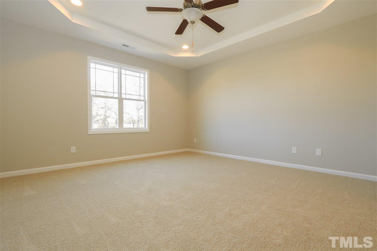 1035 2 Claude Road Willow Spring, NC 27592 - Photo 10 of 18 an empty room with a window and a fan